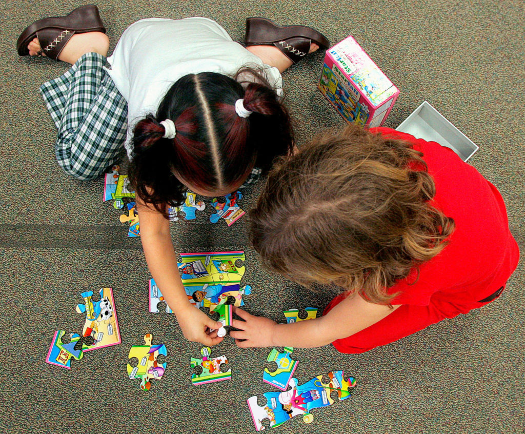Two girls work on a jigsaw puzzle in a kindergarten class at Garfield Elementary School in Everett. The district is launching a new Transitional Kindergarten Program this month. (Michael V. Martina / The Herald)
