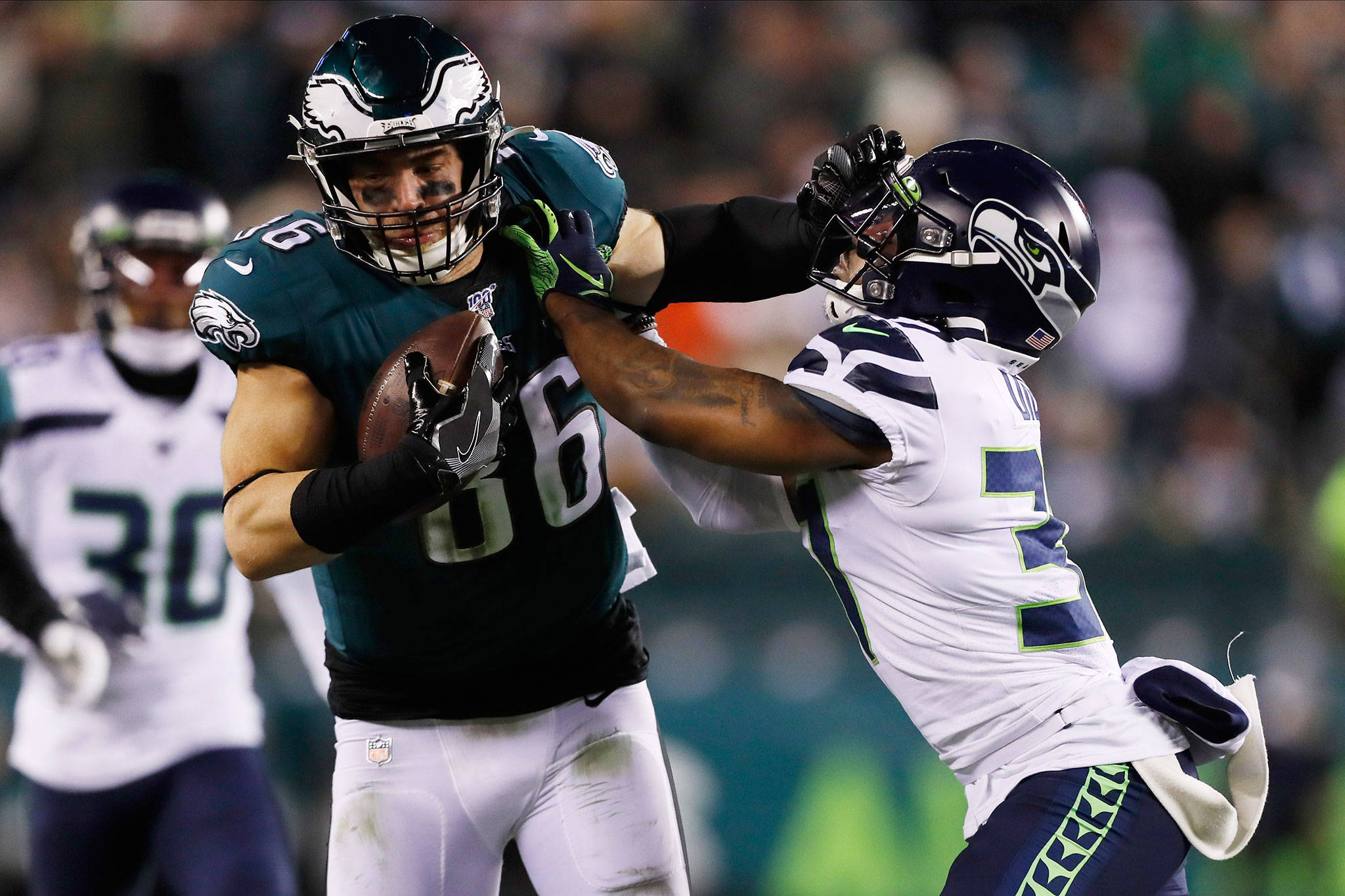 The Eagles’ Zach Ertz (left) tries to hold off the Seahawks’ Quandre Diggs during the second half of a wild-card playoff game this past Sunday in Philadelphia. (AP Photo/Julio Cortez)