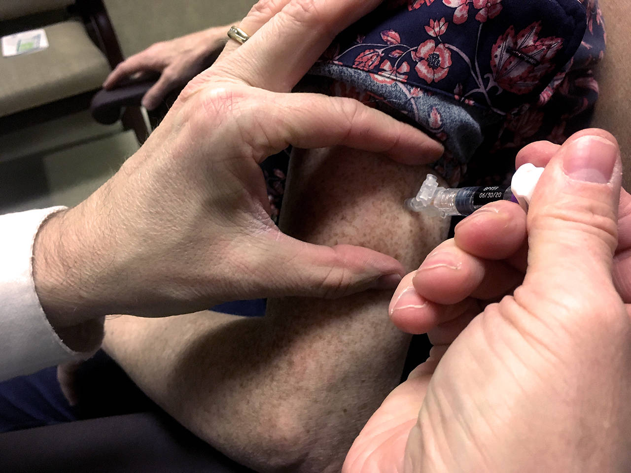 A woman gets a flu shot at a Safeway pharmacy in Everett in October. (Sue Misao / Herald file)