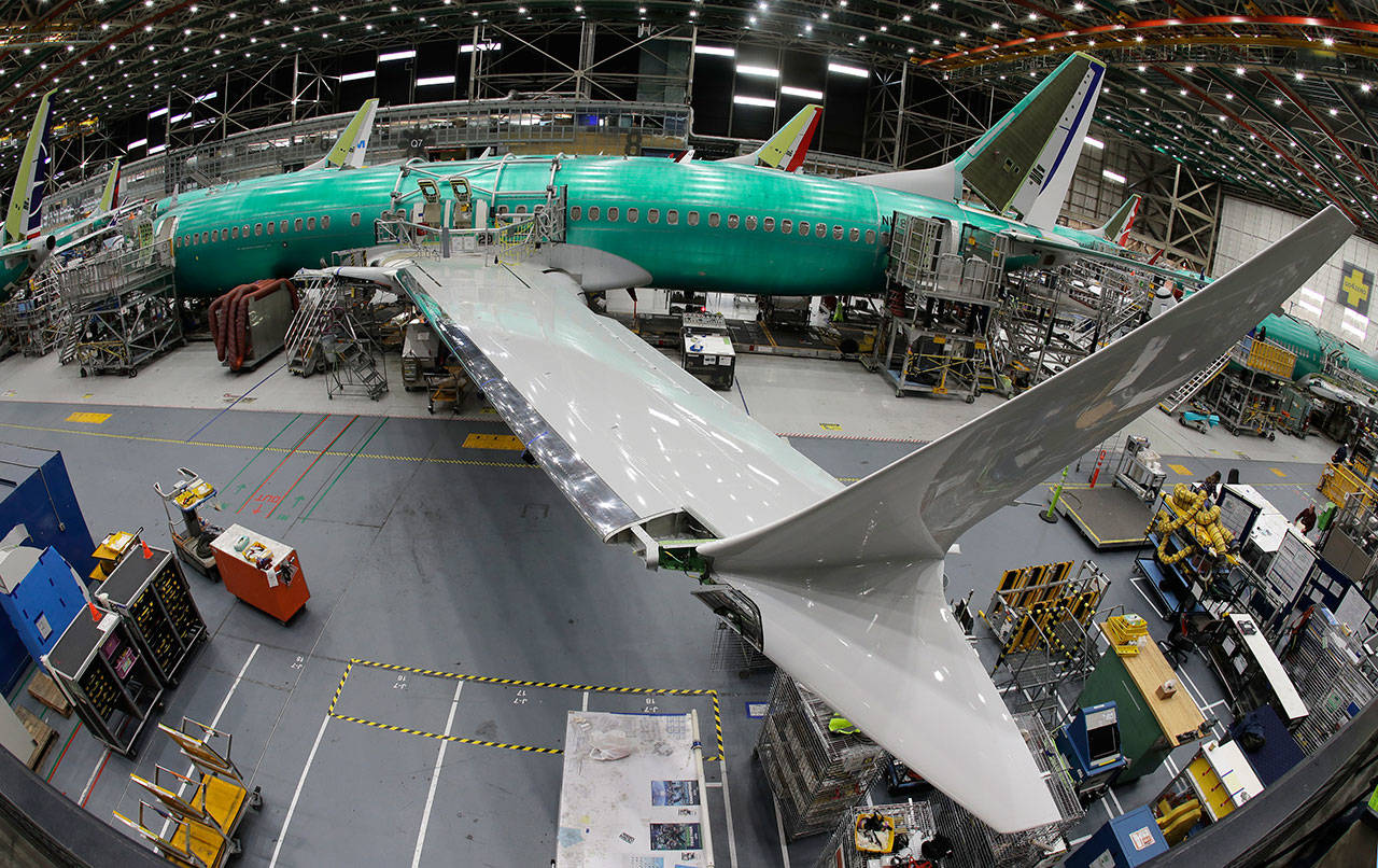 In this March 27, photo taken with a fish-eye lens, a Boeing 737 MAX 8 airplane sits on the assembly line during a brief media tour in Boeing’s 737 assembly facility in Renton. The looming production shutdown of Boeing 737 Max jets is taking a toll on a key supplier. Spirit AeroSystems Holdings Inc. is asking employees if they will take voluntarily buyouts. Spirit suspended production of fuselages and other parts for the Max on Jan. 1 after Boeing told the Wichita, Kansas, company to suspend shipments. (AP Photo/Ted S. Warren)