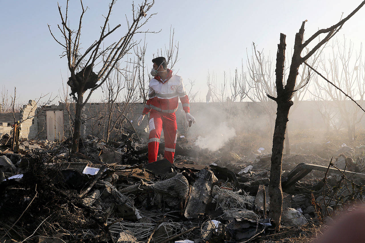 A rescue worker searches the scene where an Ukrainian plane crashed in Shahedshahr, southwest of the capital Tehran, Iran, on Wednesday. A Ukrainian airplane carrying 176 people crashed on Wednesday shortly after takeoff from Tehran’s main airport, killing all onboard. (AP Photo/Ebrahim Noroozi)