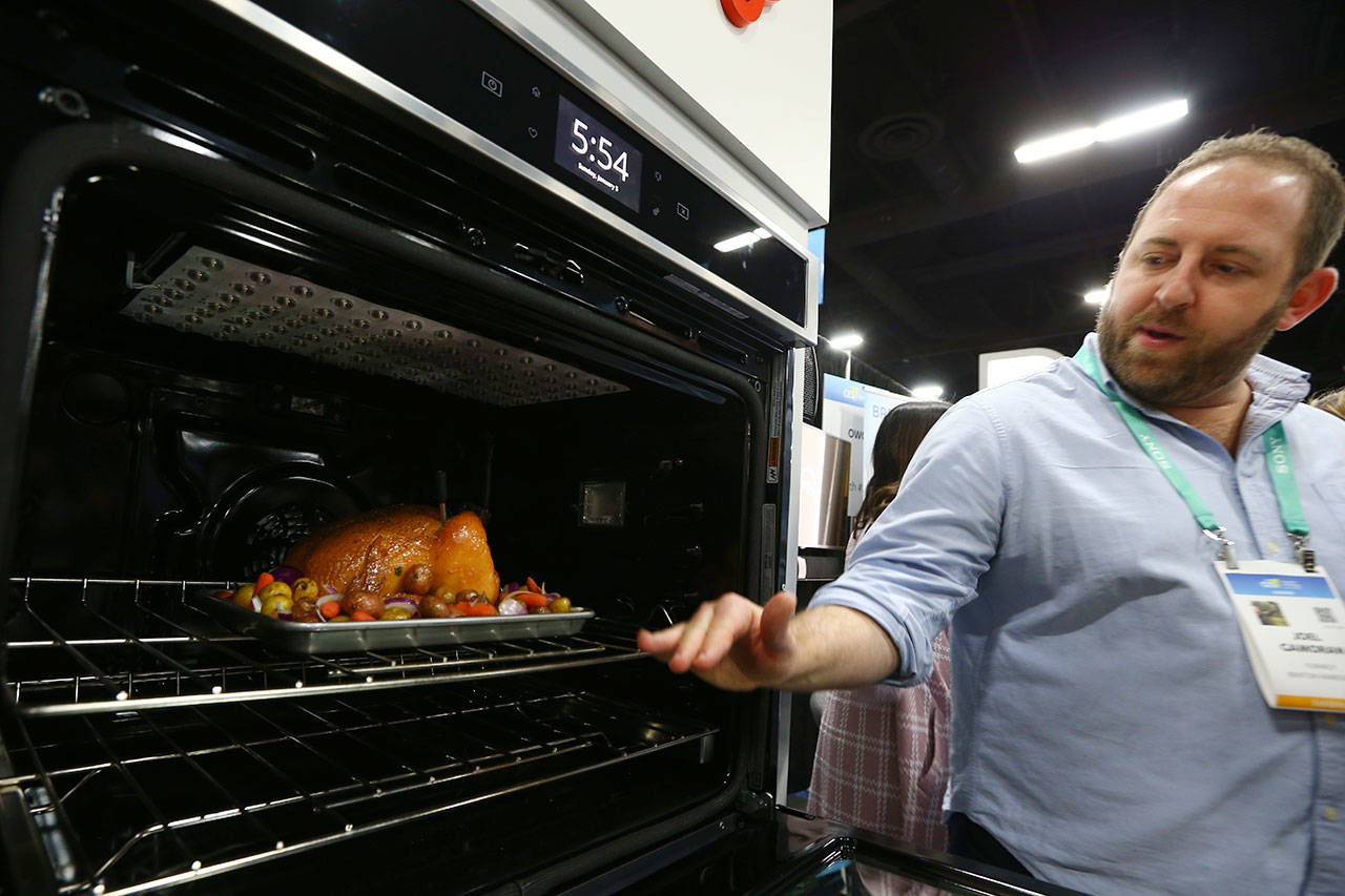 Joel Gamoran, of Yummly, demonstrates the Whirlpool Yummly temperature gauge Sunday at the CES Unveiled media preview event in Las Vegas. The smart thermometer consists of a probe and a dock, which communicate to each other and to the Yummly mobile app via Bluetooth, monitoring the temperature of the food and the temperature inside the oven. (AP Photo/Ross D. Franklin)