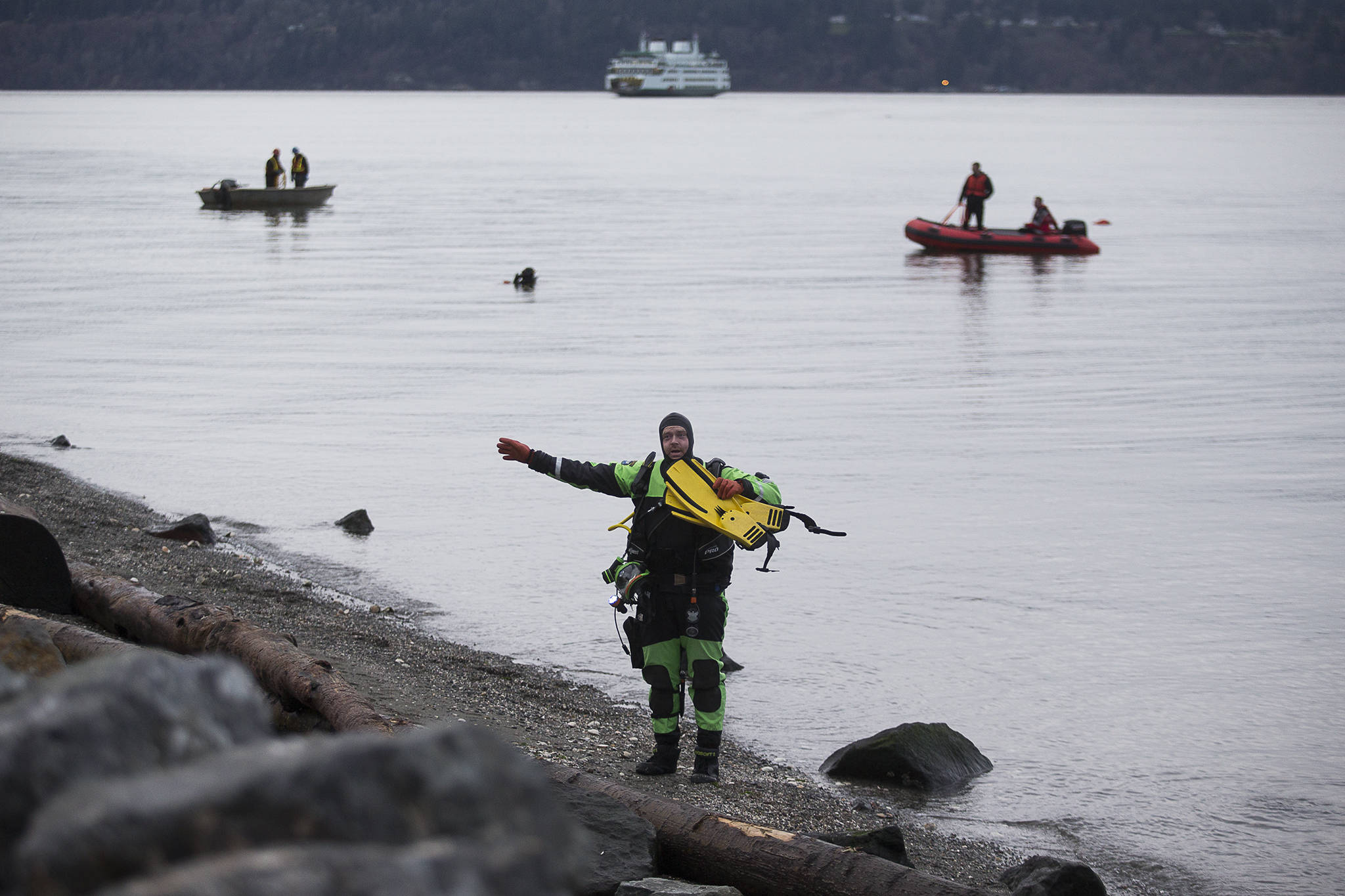 A Snohomish County Sheriff’s Office diver uses hand signals to ask an eyewitness to help him during the search for a man who fell off a boat north of the Mukilteo ferry terminal Wednesday. (Andy Bronson / The Herald)