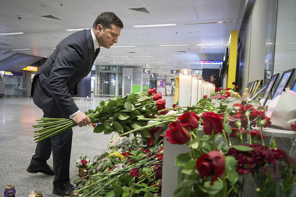 Ukrainian President Volodymyr Zelenskiy lays flowers at a memorial of the flight crew members of the Ukrainian 737-800 plane that crashed on the outskirts of Tehran, at Borispil international airport outside in Kyiv, Ukraine, on Thursday. (Ukrainian Presidential Press Office via AP)
