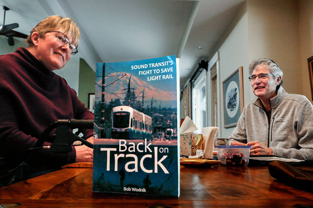In her Mill Creek area home, Joni Earl, former Sound Transit CEO, and author Bob Wodnik talk about the transit agency’s decades-long effort to bring light rail to the region. Wodnik, a former Herald writer, has written “Back on Track,” a new book about the battles for light rail. (Dan Bates / The Herald)