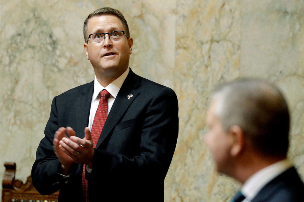 Rep. Matt Shea, R-Spokane Valley, stands at his desk on the House floor Monday during on the first day of the 2020 session of the Washington Legislature at the Capitol in Olympia. Shea returned to the capital amid calls for his resignation in the wake of a December report that found he was involved in anti-government activities. (AP Photo/Ted S. Warren) 
