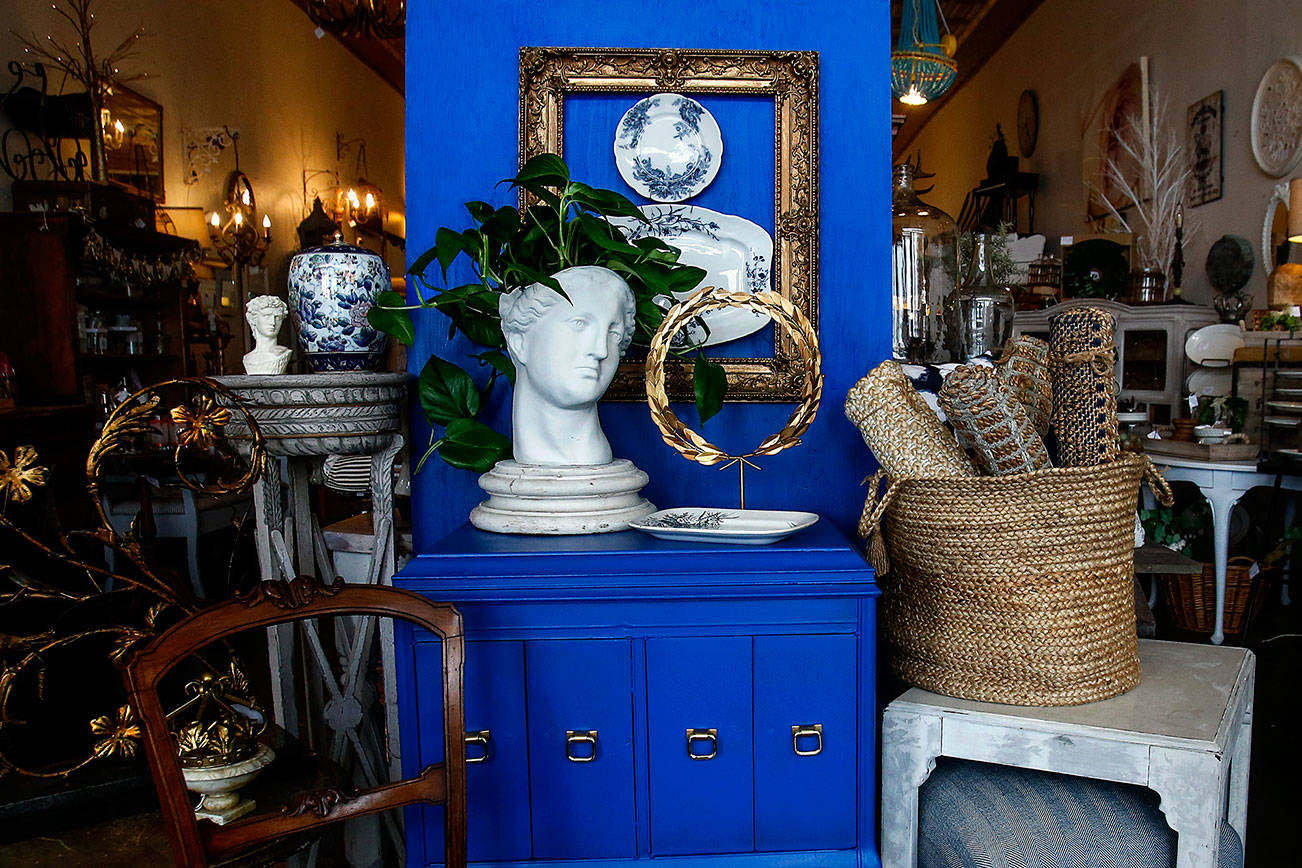 Interior designer Kelly DuByne shows off Pantone’s Color of the Year, classic blue, with a setting featuring an antique Victrola cabitnet painted with the color and staged with neutral colors and strong white accents. (Dan Bates / The Herald)