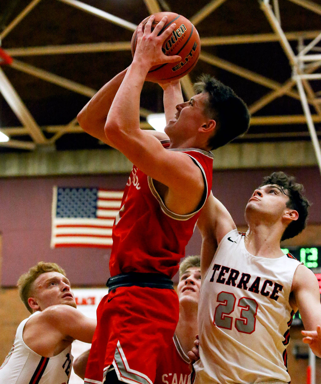 Stanwood’s Jake Cleary (center) attempts a shot with Mountlake Terrace’s Bradey Blackmer (left) and Robbie Baringer defending Friday night at Mountlake Terrace High School. The Spartans won 53-51. (Kevin Clark / The Herald)