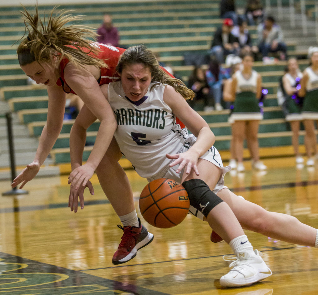 Edmonds-Woodway’s Mia Dickenson fights Snohomish’s Sara Rodgers for the ball near the baseline during a Wesco 3A/2A game Friday in Edmonds. Dickenson and the Warriors improved to 5-0 in league play with a 44-33 win over the Panthers. (Olivia Vanni / The Herald).
