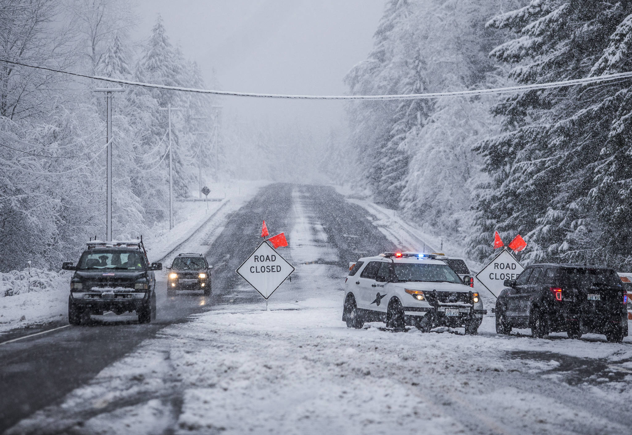 Index residents make their way westbound Monday on the closed U.S. 2, in Gold Bar. The highway was closed at milepost 32 to everyone except Index residents, who were required to have a State Patrol escort to travel east into Index. (Olivia Vanni / The Herald)