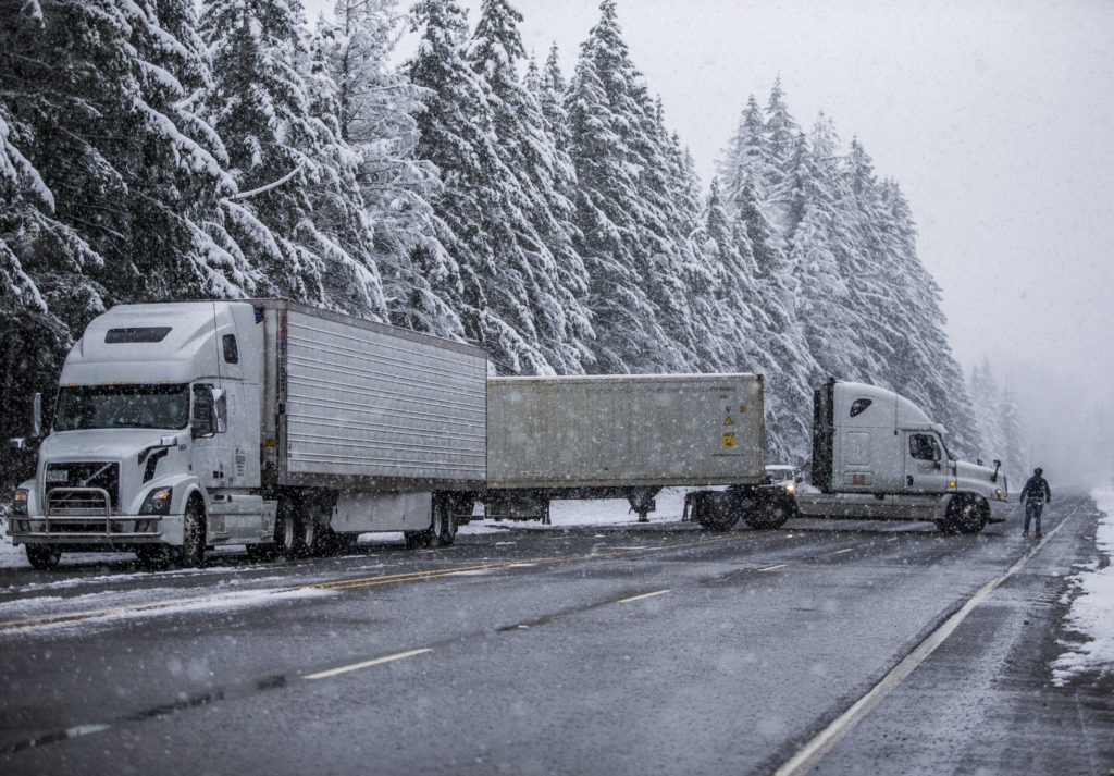 Semitrailer trucks that had been waiting at the U.S. 2 closure turn around on Monday in Gold Bar. The highway was closed indefinitely because of heavy snow accumulation and power lines and trees falling over the road. (Olivia Vanni / The Herald) 
