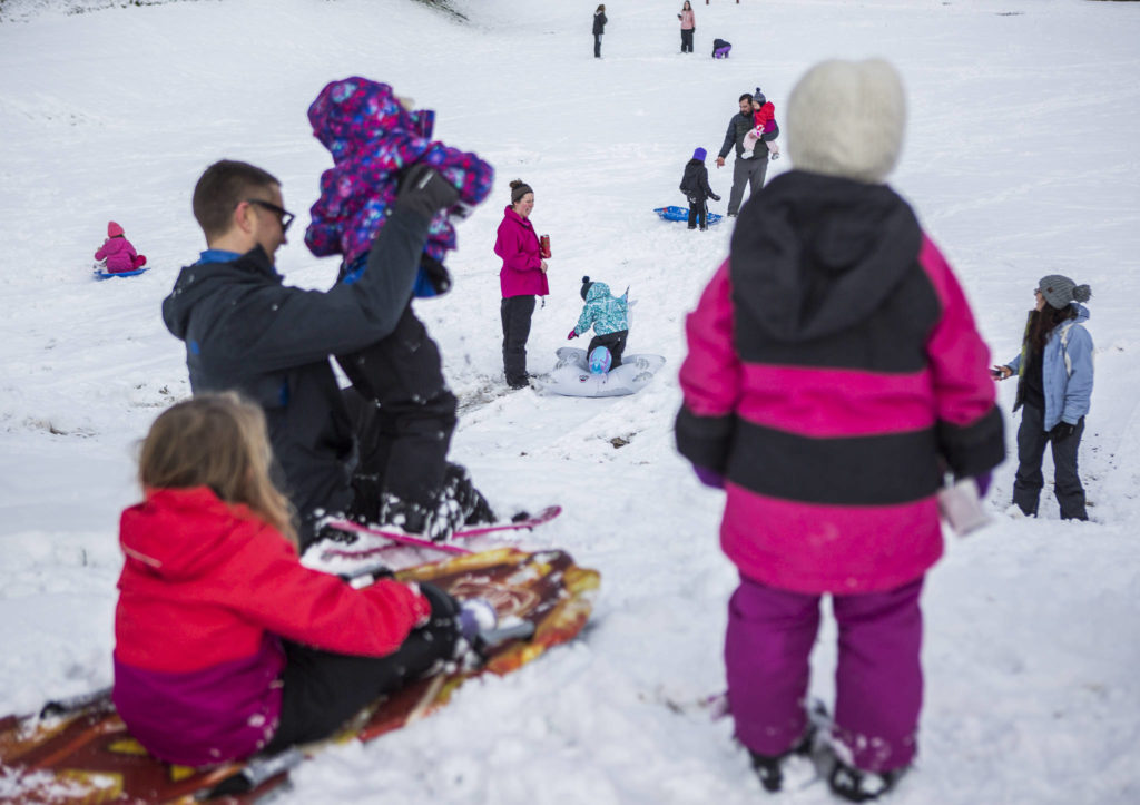 View Ridge-Madison neighborhood residents enjoy the snow Monday in Everett, where school was cancelled. (Olivia Vanni / The Herald) 
