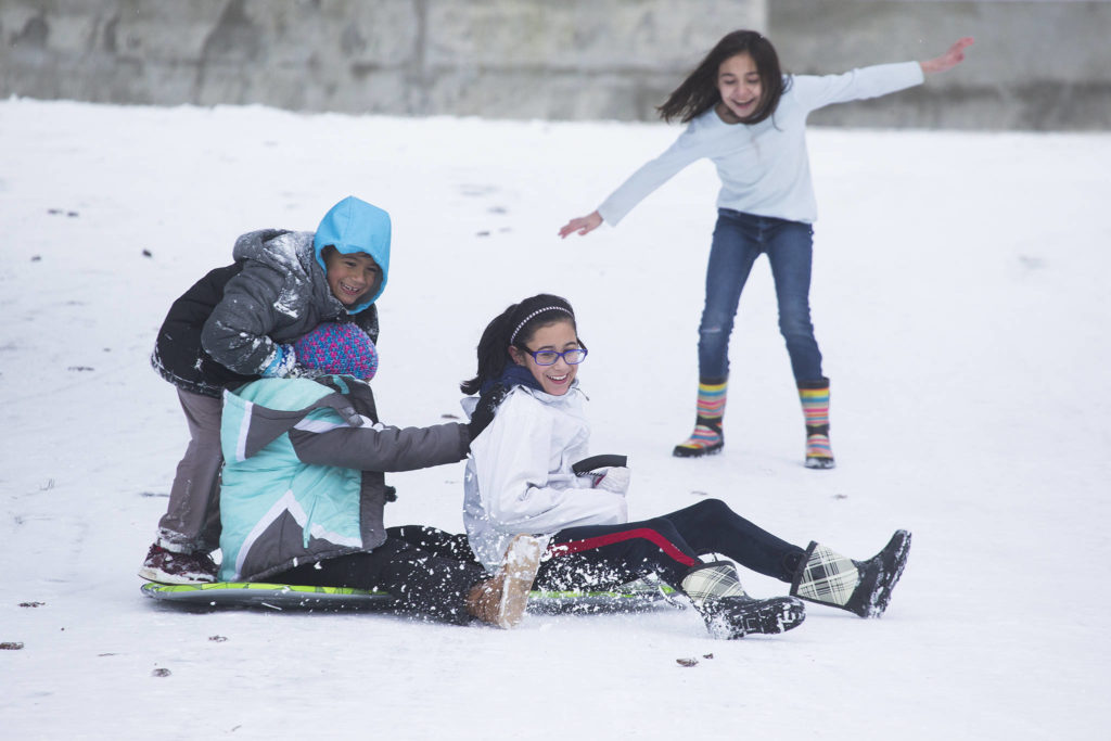Milah Redding, right, tries to keep her balance after trying to jump on a sled with friends, Julian Guzman, Peyton Donovan, and Sofia Guzman on Tuesday, Jan. 14, 2020 in Arlington, Wash. (Andy Bronson / The Herald)
