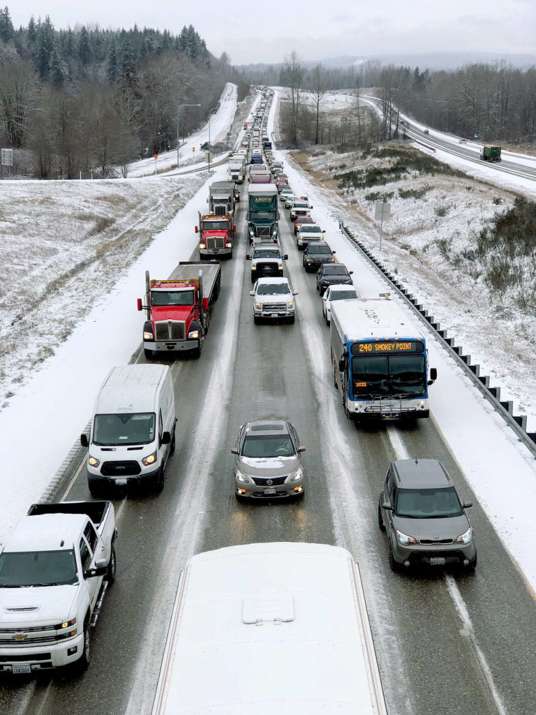 Traffic on snowy southbound I-5 at the exit for 236th Street NE was crawling Tuesday morning. (Andy Bronson / The Herald) 
