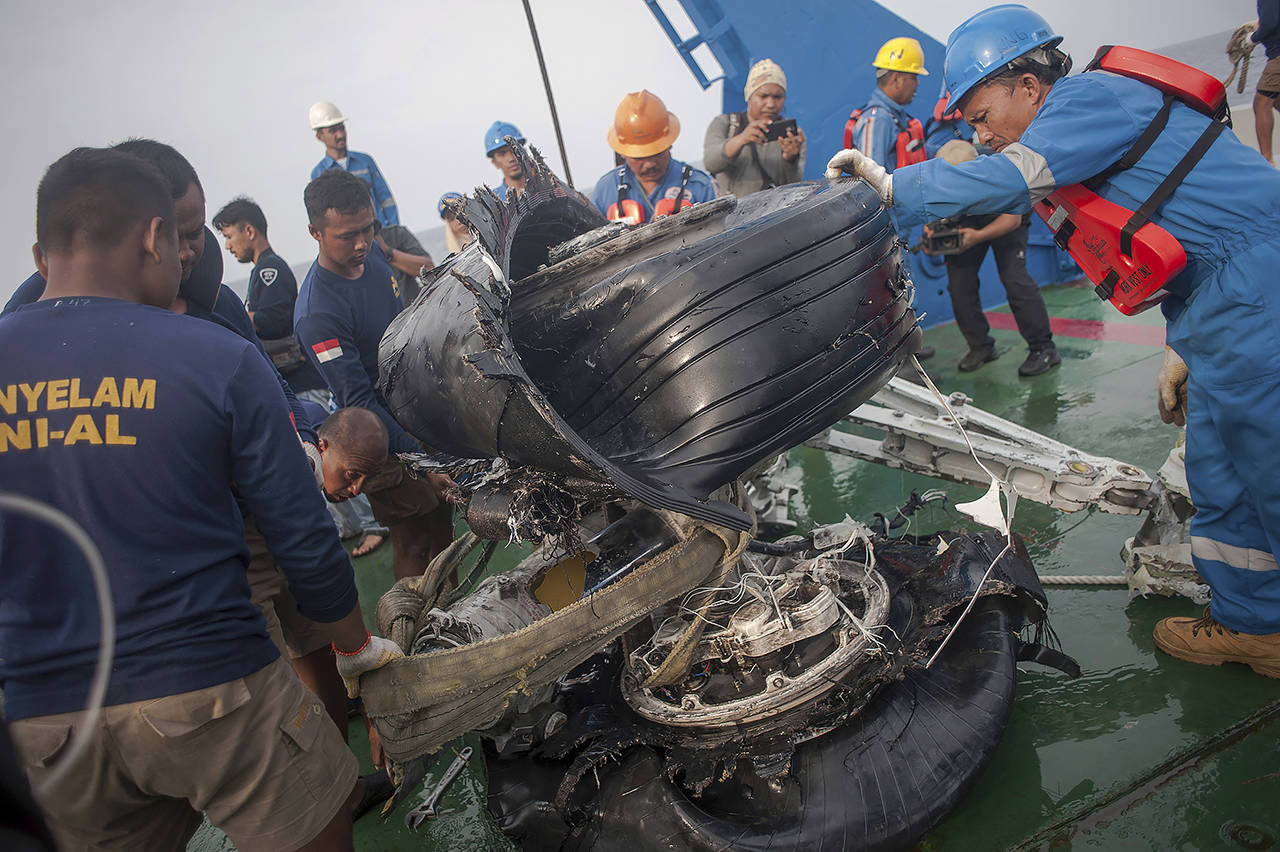 In this Nov. 4, 2018 photo, rescuers inspect part of the landing gear of the crashed Lion Air jet retrieved from the sea floor in the waters of Tanjung Karawang, Indonesia. (AP Photo/Fauzy Chaniago, file)