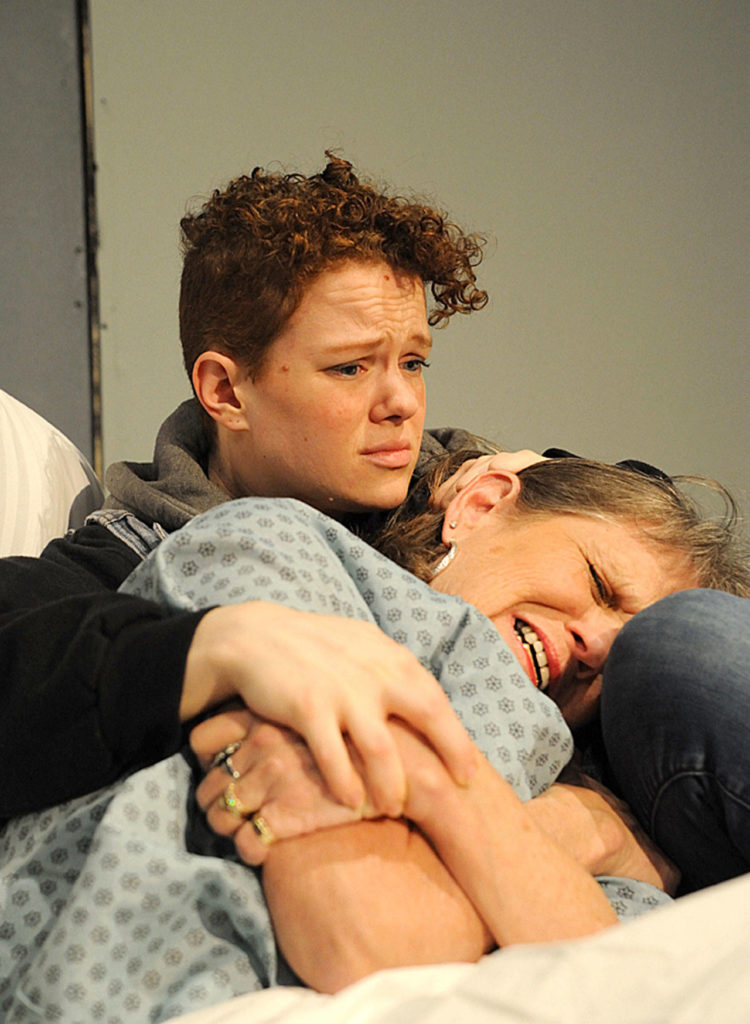 Karla (Bethany Roddy) comforts her mother, Marcie (Dawn Cornell), who’s in a hospital bed recovering from surgery for ovarian cancer. (Larry T. Lisk)
