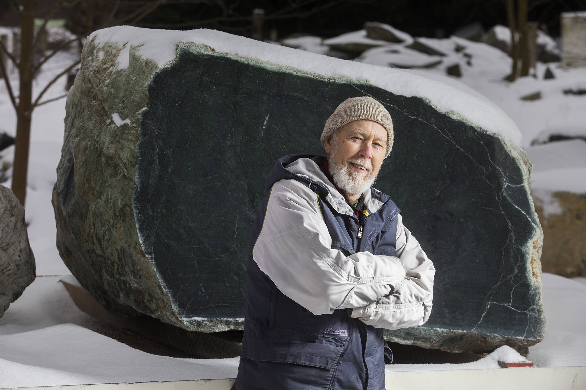 Arlington prospector Ed Molsee stands in front of a 16,000-pound jade boulder, he and fellow prospector Jason Henry, of Marblemount, discovered in the Darrington area. (Andy Bronson / The Herald)