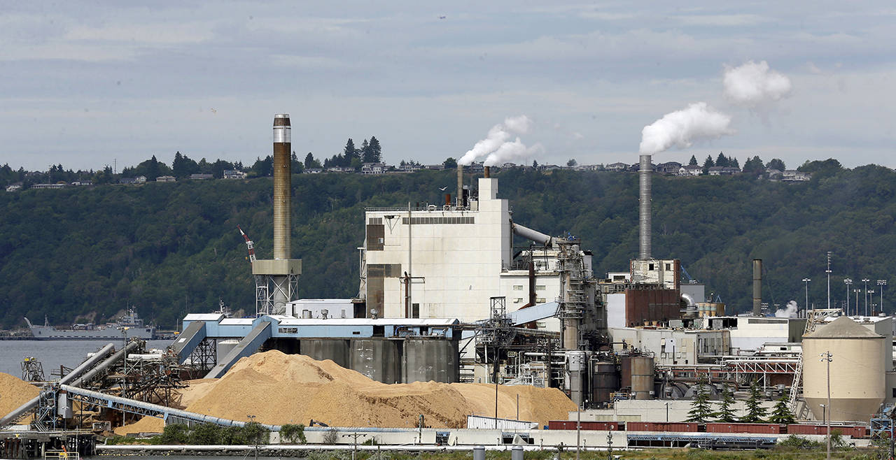 In this 2016 photo, piles of wood chips sit near the RockTenn paper mill in Tacoma. (AP Photo/Ted S. Warren, File)