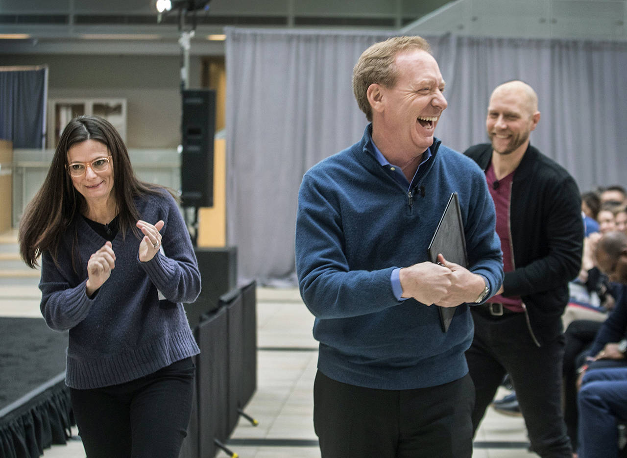 After announcing the Microsoft Carbon Footprint reduction, CFO Amy Hood, President Brad Smith and Chief Environmental Officer Lucas Joppa leave the atrium on Thursday in Redmond. (Steve Ringman/The Seattle Times via AP)