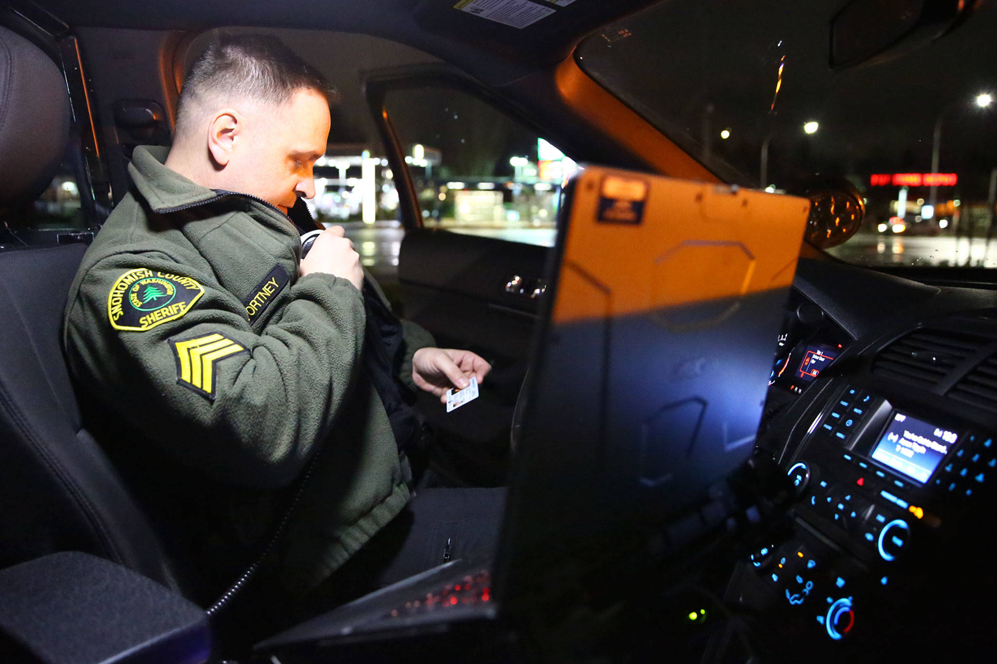 Adam Fortney calls in a drivers license during a traffic stop in Everett on Dec. 31, 2019. (Kevin Clark / The Herald)                                Adam Fortney calls in a drivers license during a traffic stop in Everett on Dec. 31, 2019. (Kevin Clark / The Herald)