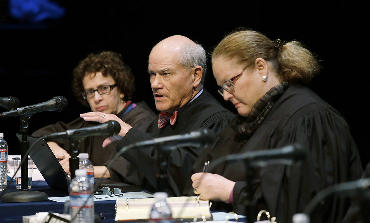 Washington Supreme Court Justice Charles K. Wiggins (center) speaks as fellow Justice Sheryl Gordon McCloud (left) and then-Justice Mary E. Fairhurst listen during arguments in November 2016. (AP Photo/Elaine Thompson, file)