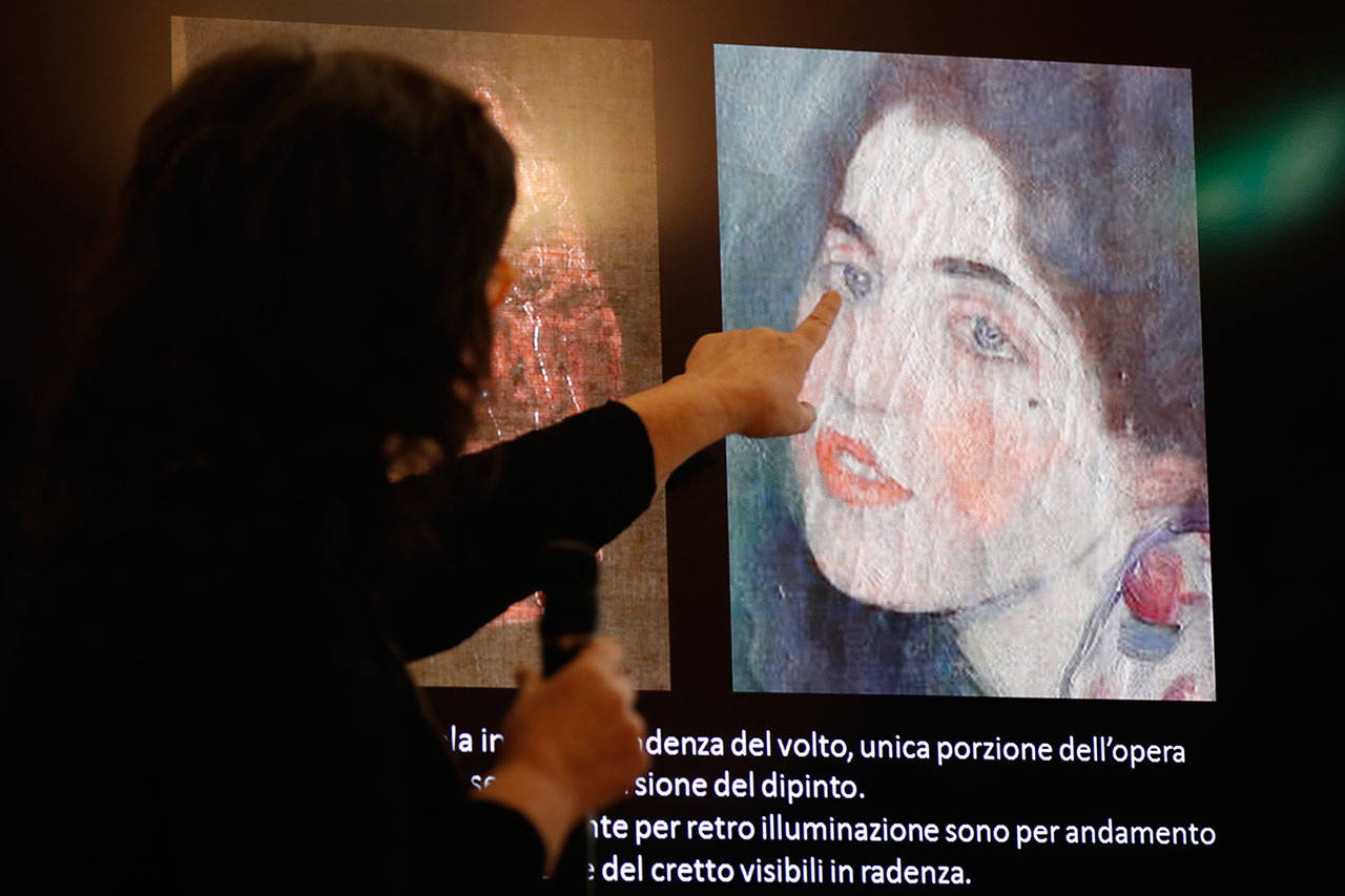 Italian art restorer Anna Selleri points at a slide showing a detail of a painting that was found last December near an art gallery and believed to be the missing Gustav Klimt’s painting “Portrait of a Lady.” (AP Photo/Antonio Calanni)