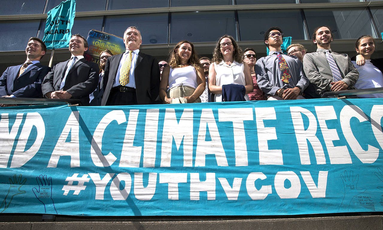 In this 2018 photo, lawyers and youth plaintiffs lineup behind a banner after a hearing before Federal District Court Judge Ann Aiken between lawyers for the Trump Administration and the so called Climate Kids in Federal Court in Eugene, Oregon. (Chris Pietsch/The Register-Guard via AP, File)