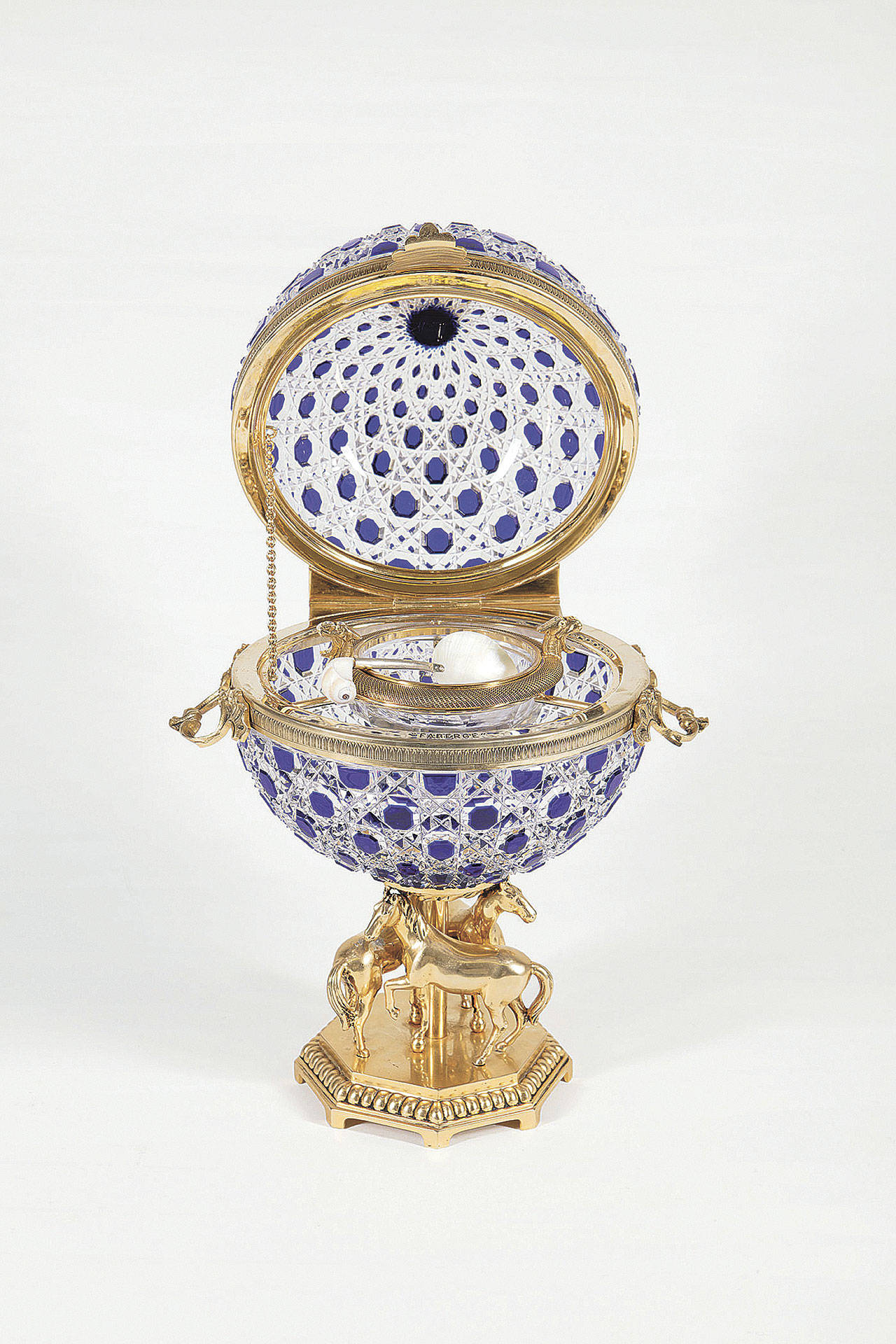 This cut-glass globe holds ice and caviar at fancy parties. It is part of the elaborate way caviar is properly served. It auctioned for over $2,000. (Cowles Syndicate Inc.)