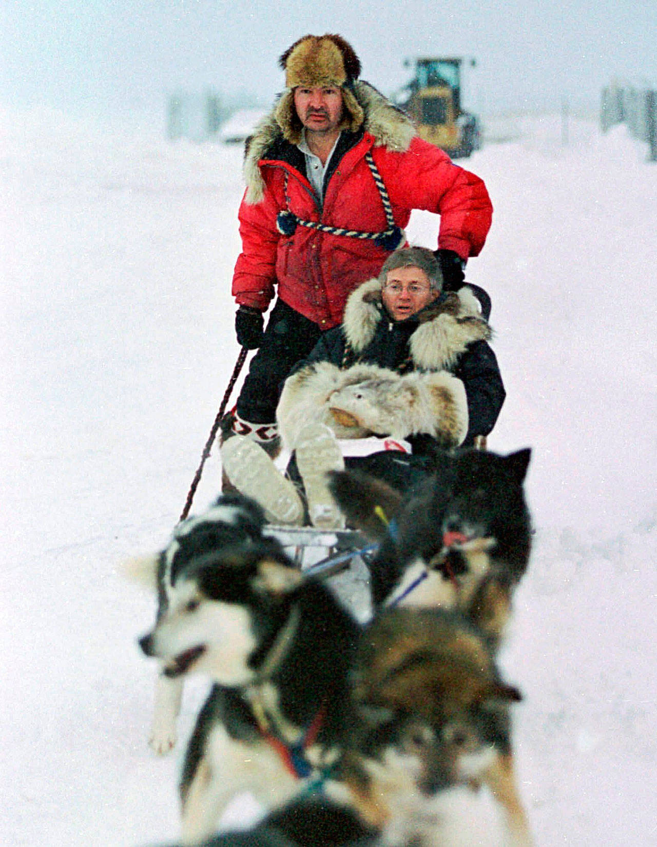 U.S. Census Bureau director Kenneth Prewitt, seated, gets a dog sled ride into town by Harold Johnson after arriving for the first count in the Eskimo village of Unalakleet, Alaska, in 2000. (AP Photo/Al Grillo, File)