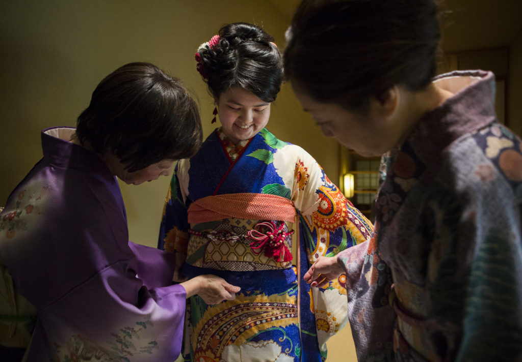 Kimono Art owners Yu Ugawa (left) and Mariko Kayama help student Kotoko Miyamae with her kimono fitting before the ceremony on Friday in Everett. (Olivia Vanni / The Herald)
