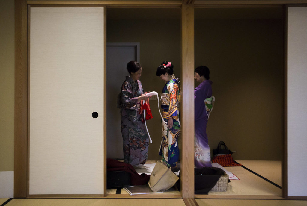 Mariko Kayama (left) and Yu Ugawa fit Kotoko Miyamae for a kimono on Jan. 24 in Everett. (Olivia Vanni / The Herald)
