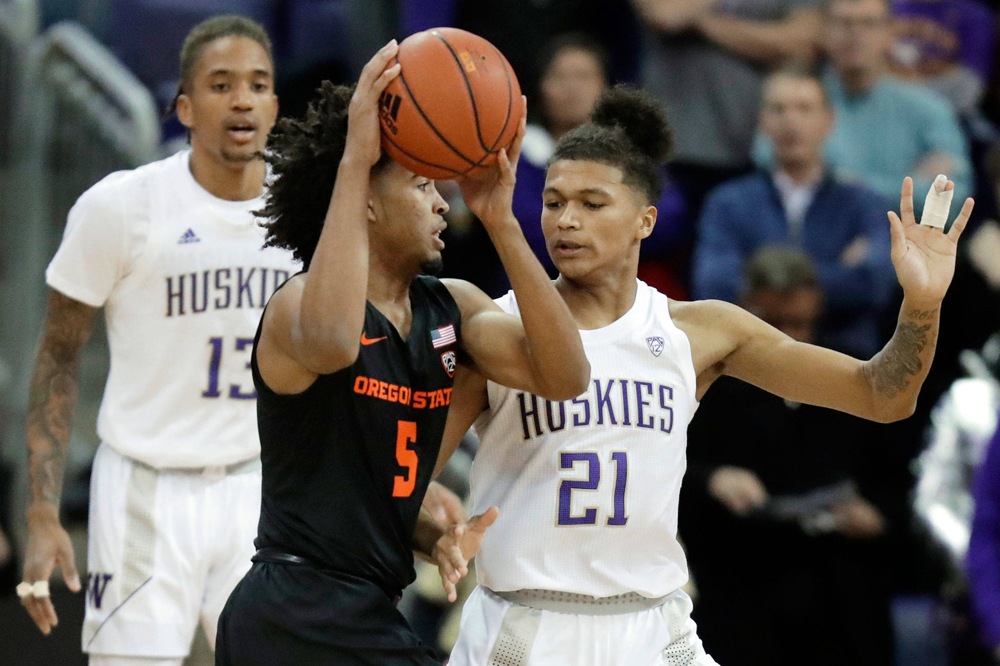 Washington forward RaeQuan Battle (21), a Marysville Pilchuck alum, defends against Oregon State guard Ethan Thompson during the first half of a game Thursday in Seattle. (AP Photo/Ted S. Warren)