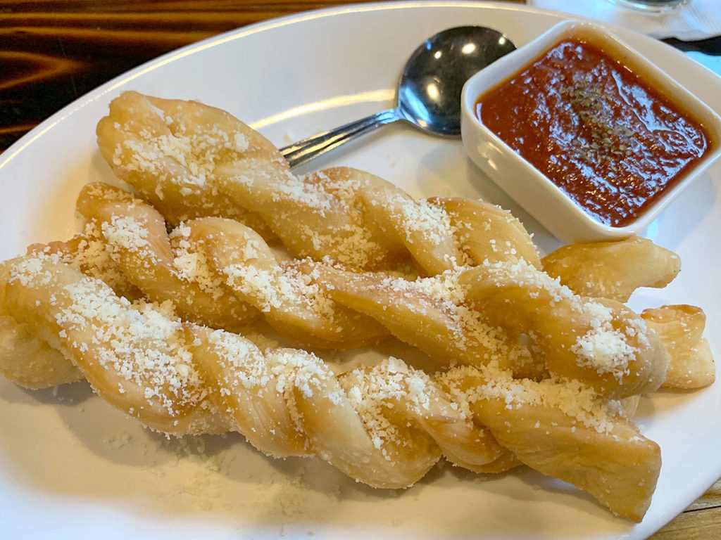 The garlic knots, sprinkled with Parmesan, are served with house-made pomodoro sauce. (Evan Thompson / The Herald)
