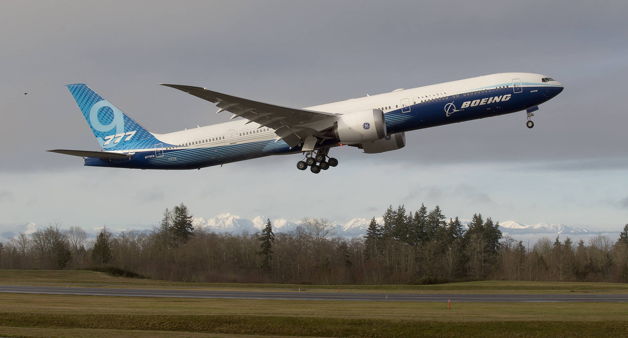 With the Olympic mountains in the background, Boeing’s 777X lifts off from Paine Field on its first flight Saturday in Everett. (Andy Bronson / The Herald)