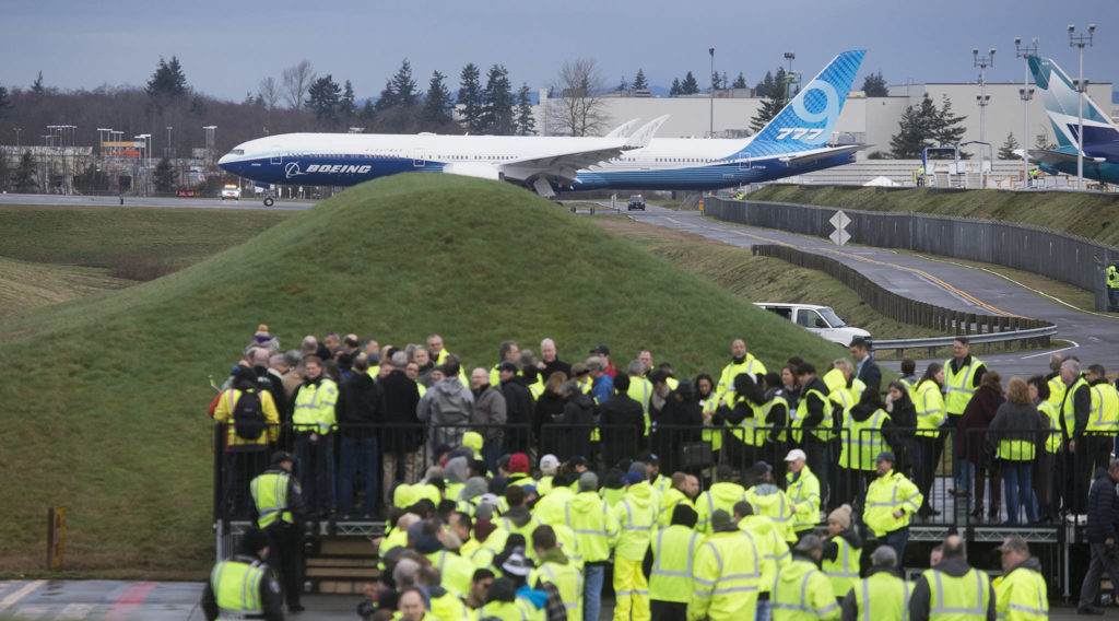Boeing employees watch the 777X taxi for takeoff from Paine Field for its first flight on Saturday in Everett. (Andy Bronson / The Herald) 

