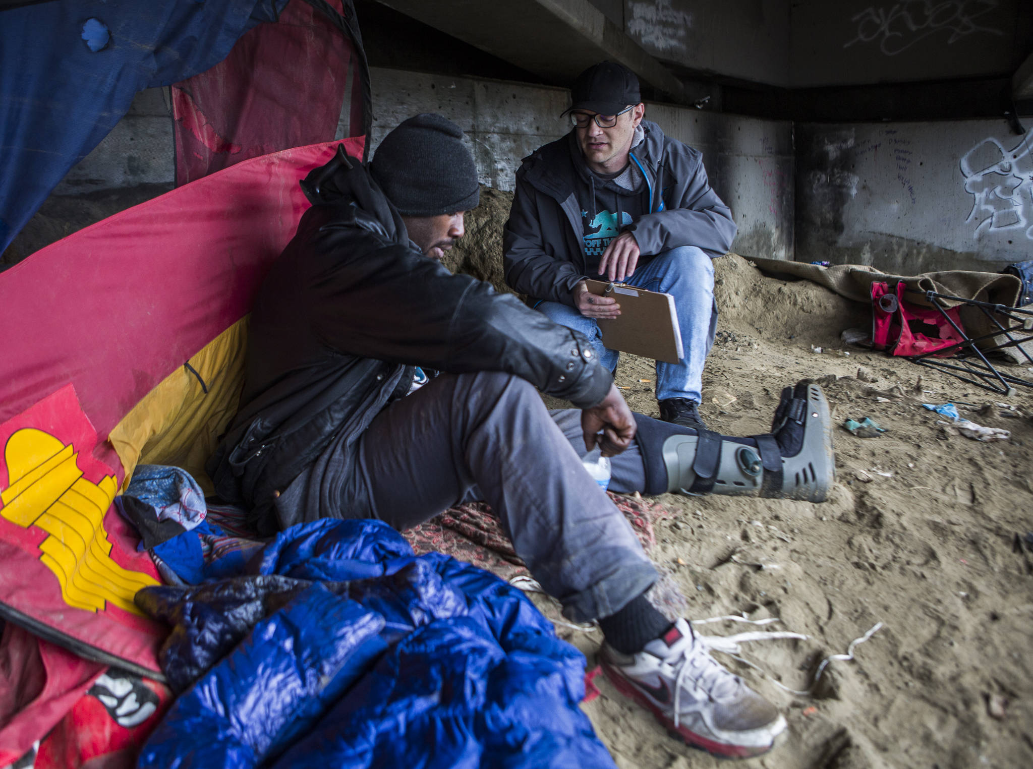 Catholic Community Services housing navigator Aaron King, right, talks with Kenny Marshall, 39, for the annual Point-in-Time Count on Thursday in Everett. (Olivia Vanni / The Herald)