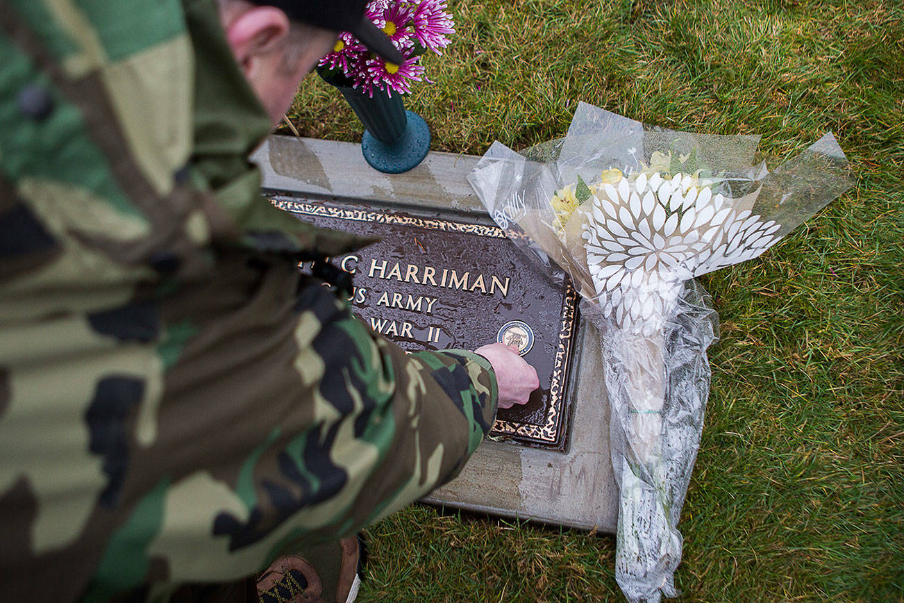 Snoqualmie Tribe treasurer Chris Castleberry places a Native Veteran medallion on Joseph Harriman’s headstone on Saturday, Jan. 25, 2020 in Monroe, Wash. The World War II veteran died in 1950. His grave site went unmarked for 70 years.(Olivia Vanni / The Herald)