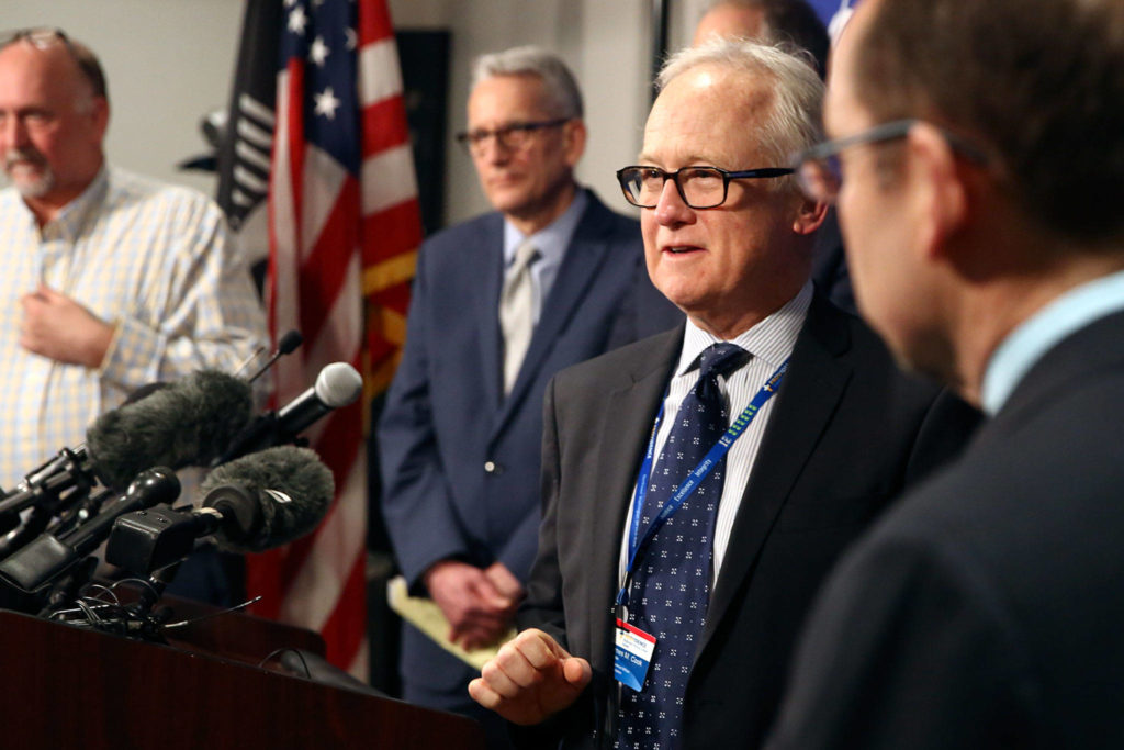 Dr. Jay Cook (second from right), chief of surgery at Providence Regional Medical Center Everett, fields questions during a news conference Tuesday at the state Public Health Laboratories in Shoreline. (Kevin Clark / The Herald)
