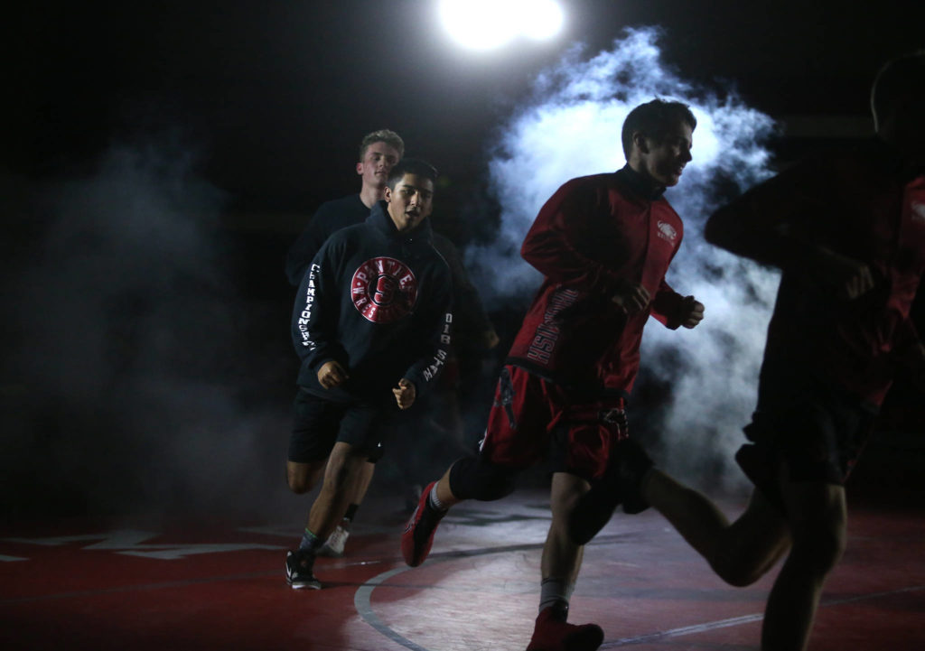 Snohomish wrestlers enter the mat with a smoke screen before introductions. Snohomish lost to Stanwood 41-39 in a boys’ wrestling meet on Tuesday, Jan. 28, 2020 in Snohomish, Wash. (Andy Bronson / The Herald)
