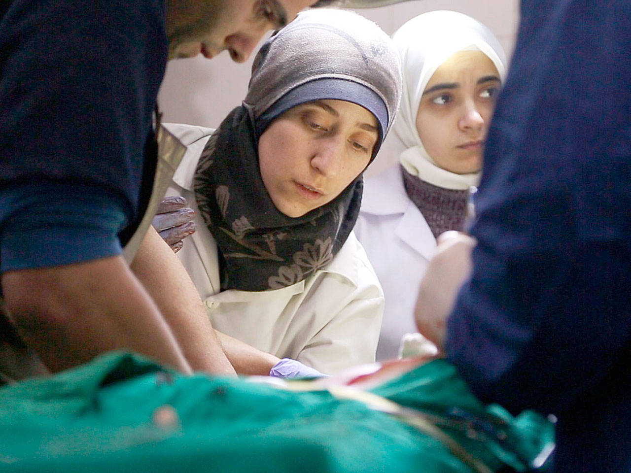 Dr. Amani Ballour, a woman physician in male-dominated and war-wracked Syria, tends to a patient in “The Cave.” (National Geographic)