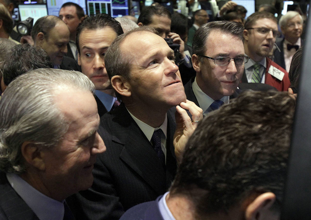 In this 2011 photo, then-Nielsen Company CEO David Calhoun (center) is seen on the floor of the New York Stock Exchange. Calhoun, Boeing’s new CEO, said Wednesday that production of the 737 Max will resume this spring. (AP Photo/Richard Drew, File)