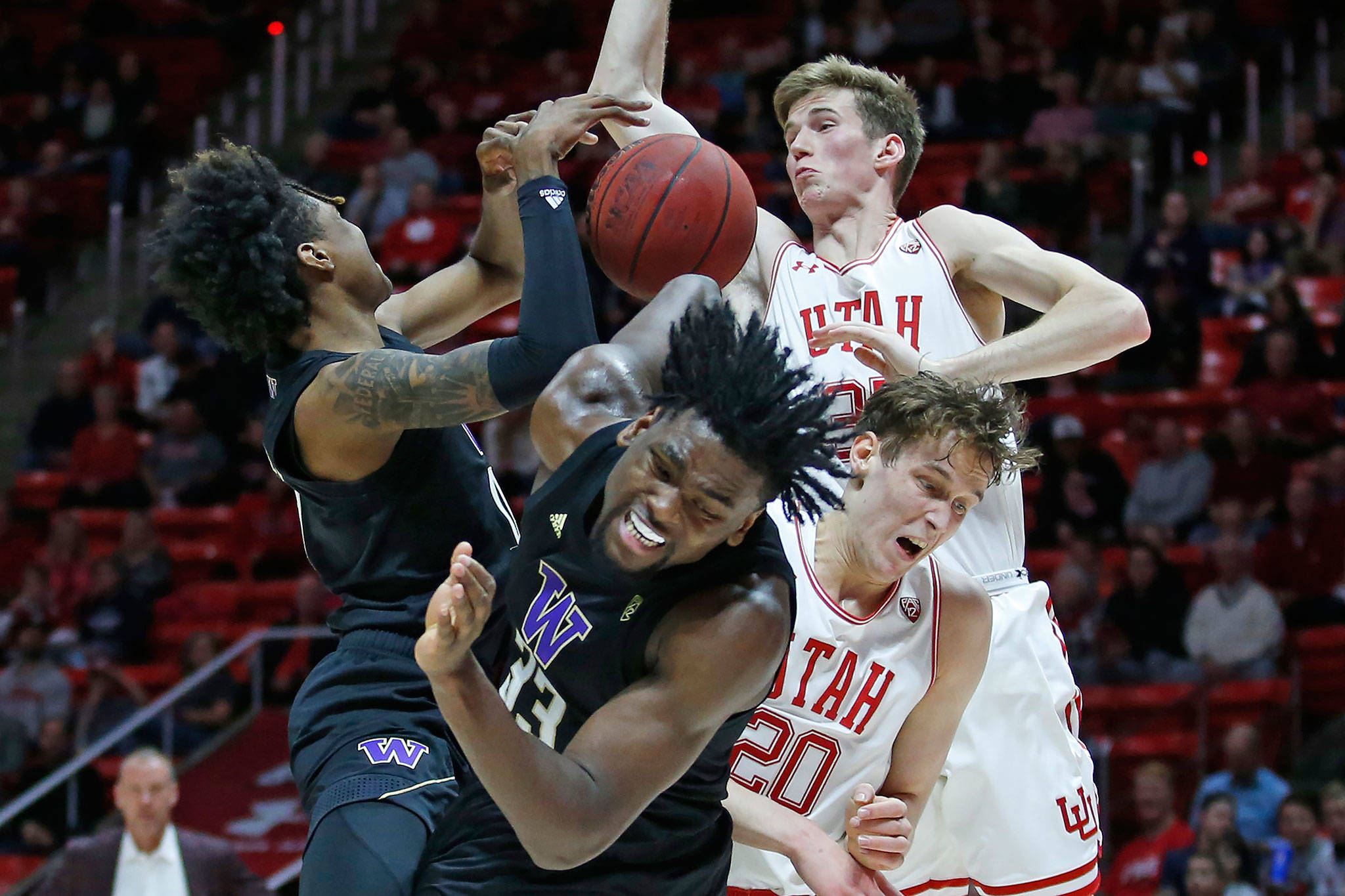 Washington’s Jaden McDaniels (left) and Isaiah Stewart (middle) battle against Utah’s Mikael Jantunen (front right) and Branden Carlson (rear) for a rebound during a game Thursday in Salt Lake City. (AP Photo/Rick Bowmer)