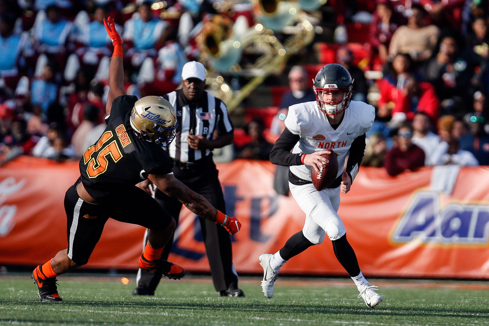 North quarterback Anthony Gordon (right), of Washington State, scrambles away from South defensive end Trevis Gipson, of Tulsa, during the second half of the Senior Bowl on Saturday in Mobile, Ala. (AP Photo/Butch Dill)