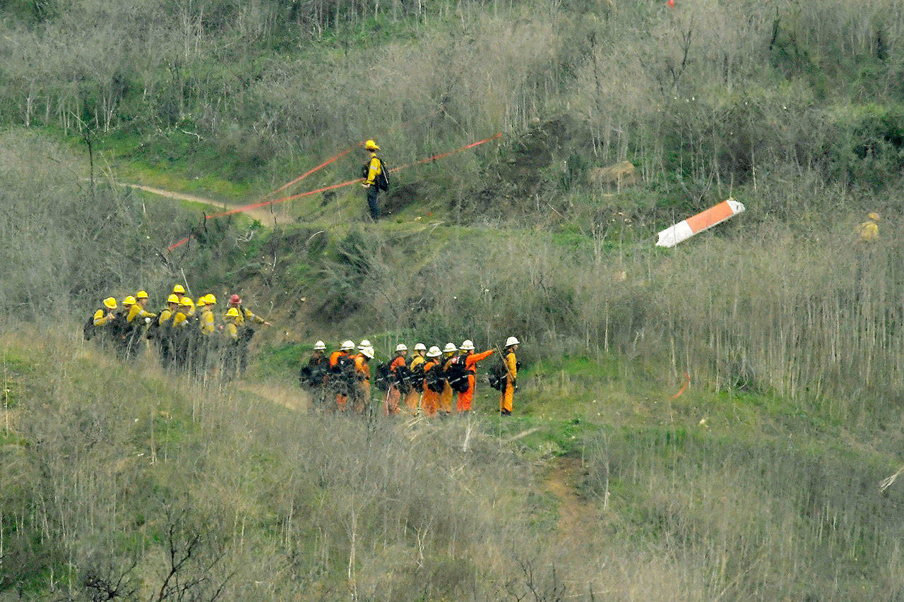 Firefighters work the scene of a helicopter crash where five people, including former NBA star Kobe Bryant, reportedly died Sunday in Calabasas, Calif. (AP Photo/Mark J. Terrill)