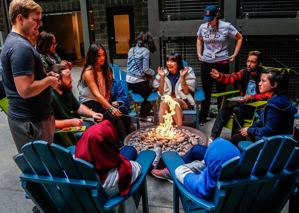 Along with a few friends, student residents at Everett Community College’s Cedar Hall roast marshmallows, play ping pong and talk around a fire in a secure open-air interior courtyard. (Dan Bates / Herald file)
