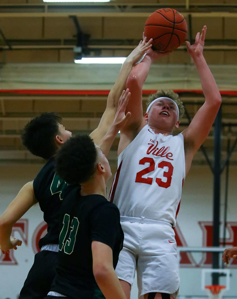 Marysville Pilchuck’s Cameron Stordahl (23) attempts a shot over Marysville Getchell’s Landyn Olson (4) and Austin Townsend (13) on Friday evening at Marysville Pilchuck High School. The Tomahawks won 61-57. (Kevin Clark / The Herald)
