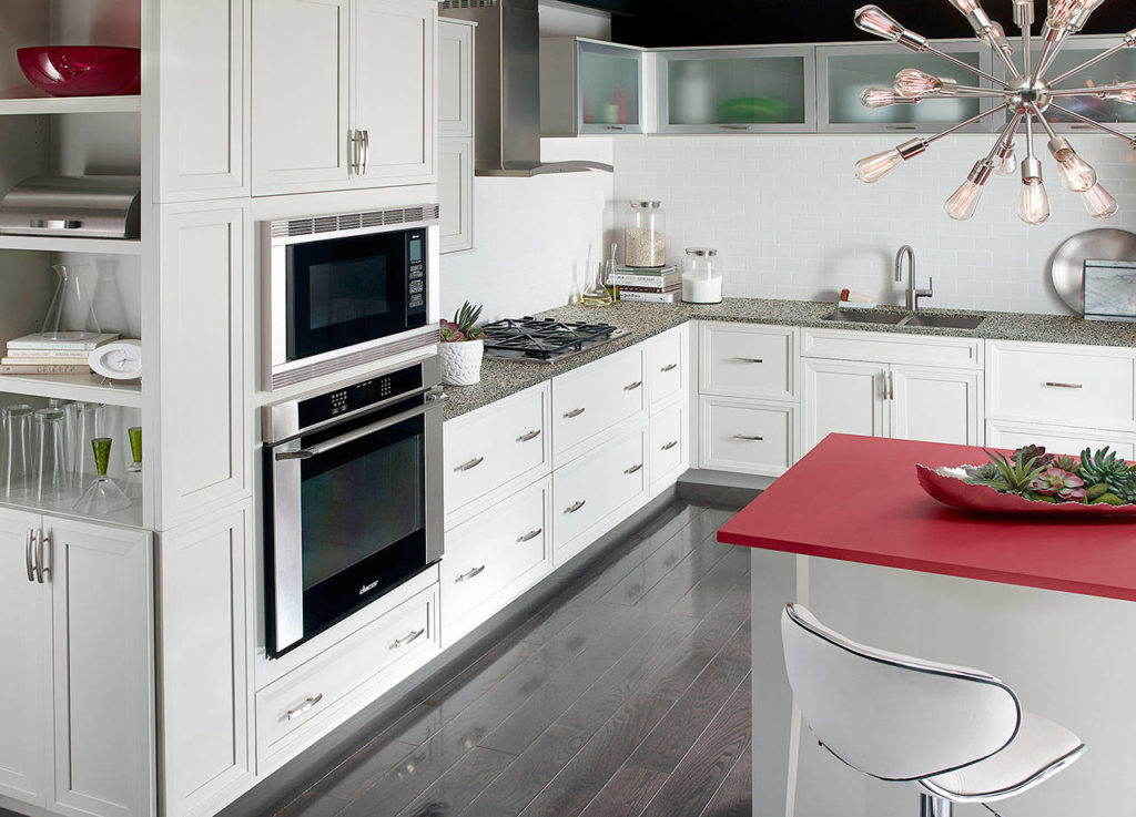 A white kitchen gets a jolt of color: The central countertop was done in Corian’s Royal Red. (Corian Design)
