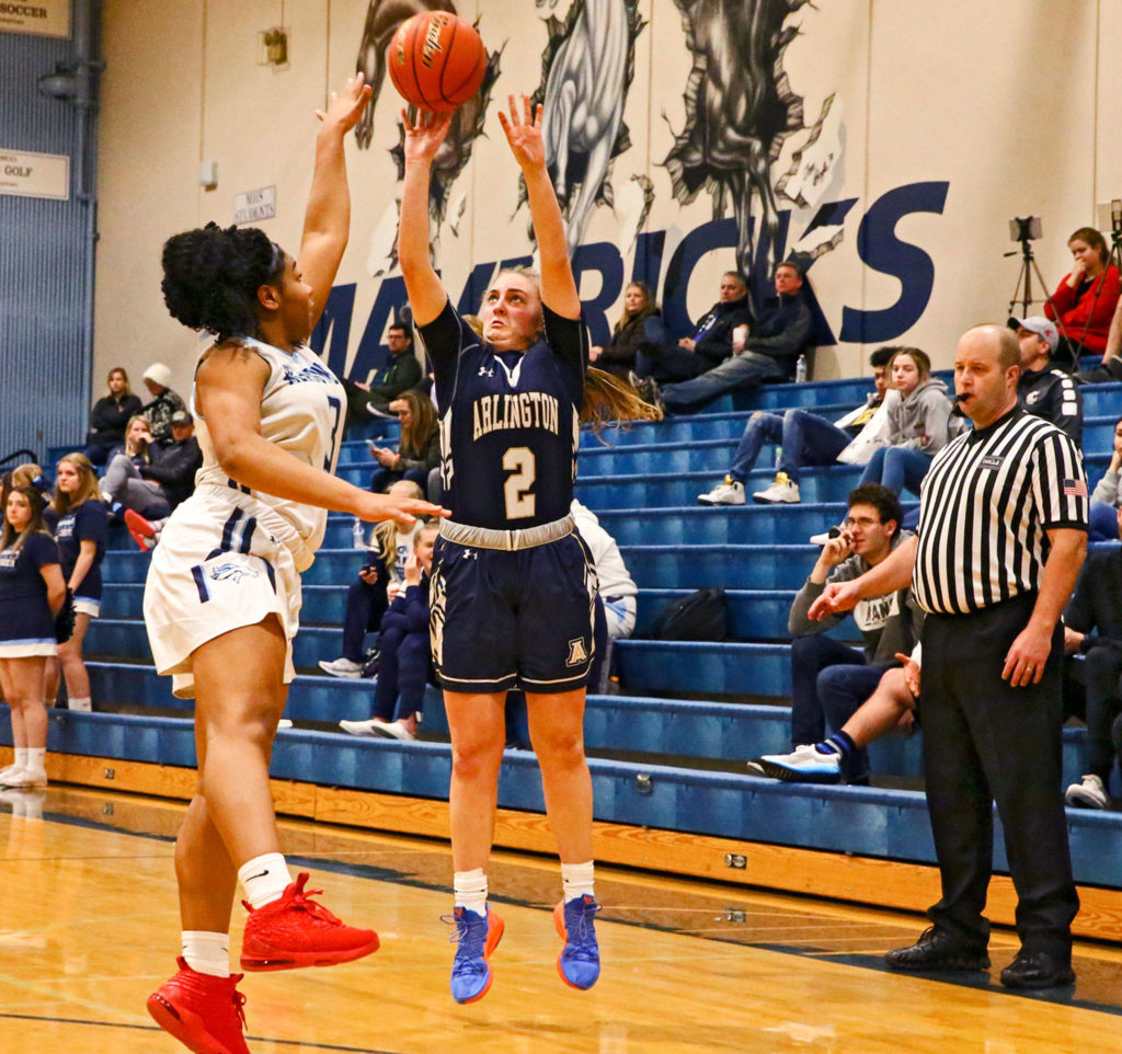 Arlington’s Hailey Hiatt attempts a 3-pointer with Meadowdale’s Alicia Morrison defending at Meadowdale High School in Lynnwood on Jan. 3. (Kevin Clark / The Herald)
