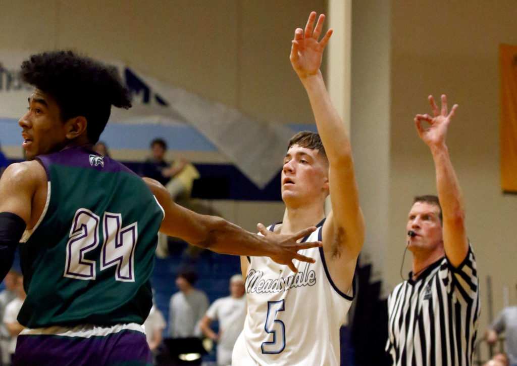 Meadowdale’s Hunter Moen watches a 3-point shot attempt with Edmonds-Woodway’s Nikko McNeal Friday evening at Meadowdale High School in Lynnwood January 24, 2019. (Kevin Clark / The Herald)
