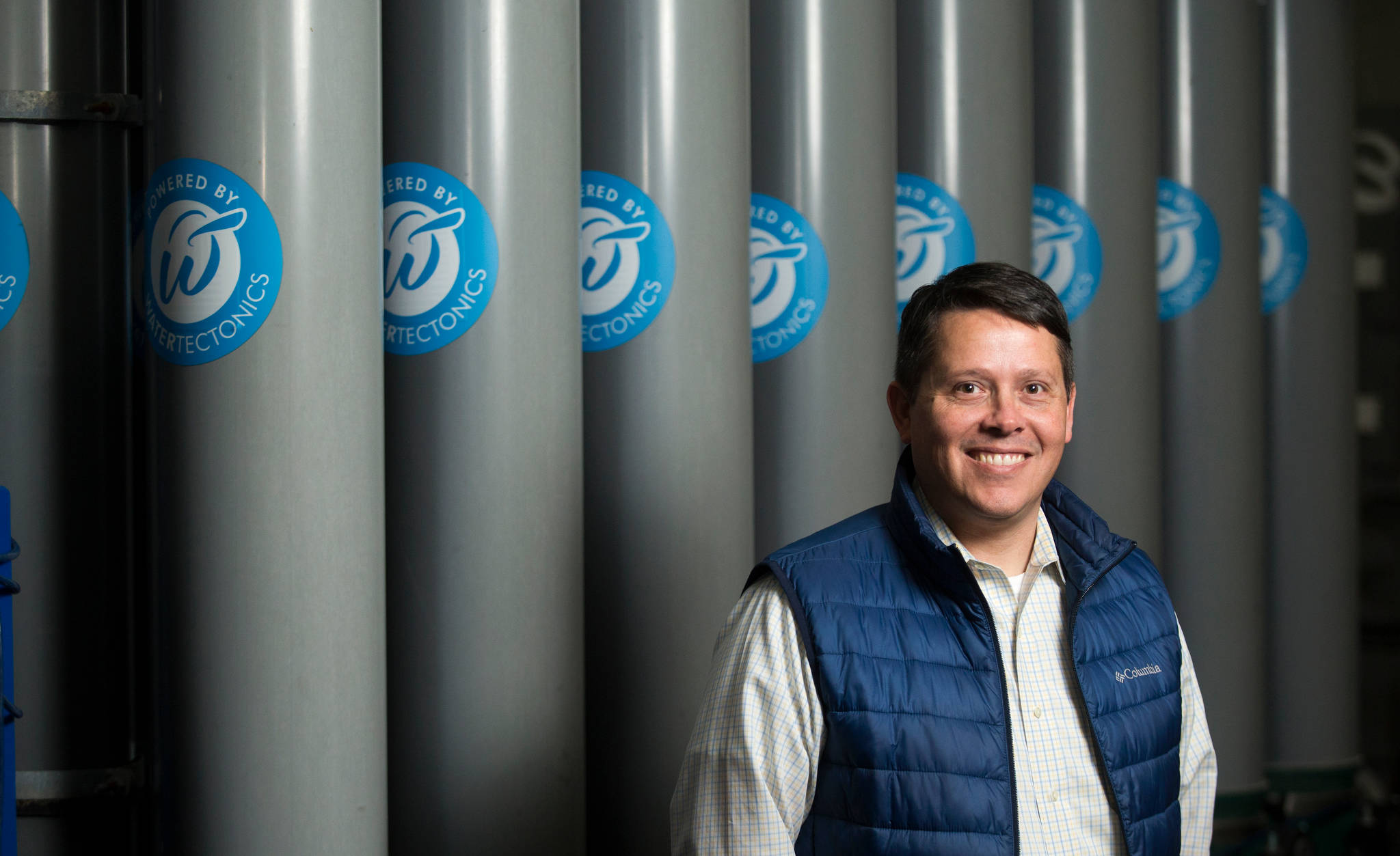 WaterTectonics Vice President Jason Mothersbaugh stands by a filtration unit at his company’s Everett headquarters. WaterTectonics builds systems that clean water used in industrial processes. (Andy Bronson / The Herald)